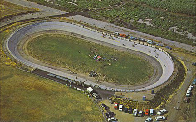 Aerial photograph of the track in its early years, cars parked around the dirt infield