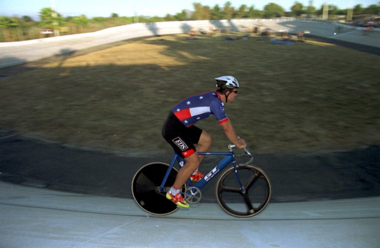 A rider in a stars-and-stripes national champion's jersey on the banking, about 2003. From the club's website of the time, recovered from the Internet Archive.
