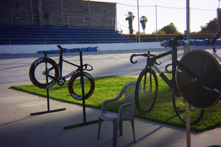 Two track bikes on stands, grandstand empty.
